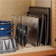 there are many plates and pans on the shelf