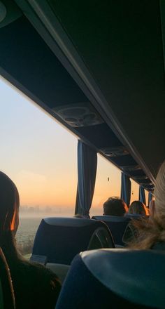 some people are sitting on a bus looking out at the water