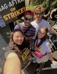 a group of people standing next to each other in front of a sign that says sag - affra on strike