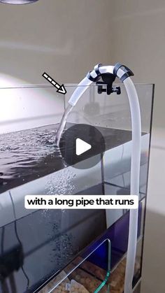 a fish tank with a long pipe that runs into the water and has an arrow pointing to it