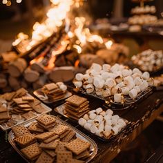 a table topped with trays of food covered in marshmallows