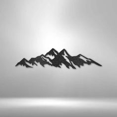 a black and white photo of mountains with the sun in the sky behind them on a gray background