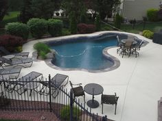 an above ground pool surrounded by chairs and tables