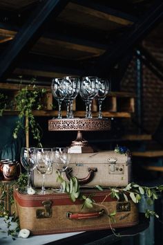 an old suitcase with wine glasses on top