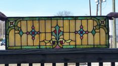 a stained glass window sitting on top of a wooden bench