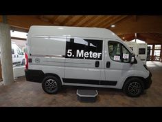 a white van parked in a garage with the number 5 meter on it's side