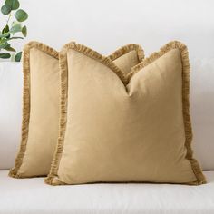 two tan pillows on a white couch