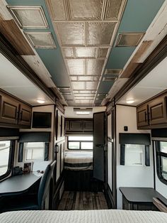 the interior of a travel trailer with wood flooring and ceiling tiles on the walls