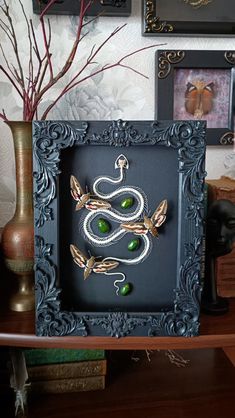 there is a snake in the frame with green beads on it's head and eyes