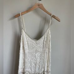 a white top hanging up on a hanger