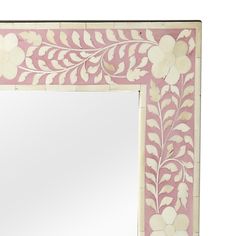 a pink and white mirror with flowers on it