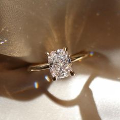 a diamond ring sitting on top of a white cloth