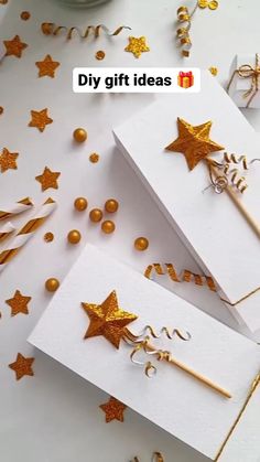 two white boxes with gold stars on them next to confetti and streamers