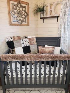 a baby crib in the corner of a room with pillows and blankets on it