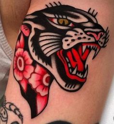 a black and red tiger with flowers on it's thigh is seen in this tattoo design