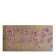 pink flowers are arranged on the side of a piece of fabric that has been stitched together