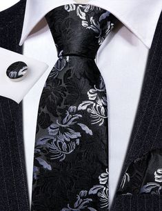 This Black White Floral Silk Tie Pocket Square Cufflink Set is the perfect addition to any formal wear ensemble. Made with high quality silk, this tie features a sophisticated black and white floral pattern that will make a statement at any wedding or special occasion. The set also includes a matching pocket square and cufflinks for a polished, put-together look. 100% Silk Handmade Package Includes: Tie, Pocket Square & Cufflinks. Length: 59" Width: 3.34" Warm iron if needed Luxury Silver Suit And Tie Accessories For Business, Silver Elegant Suit And Tie Accessories For Gift, Elegant Black Standard Tie And Suit Accessories, Elegant Silver Suit And Tie Accessories For Gift, Elegant Black Suit And Tie Accessories For Black-tie Events, Classic Black Suit And Tie Accessories For Wedding, Elegant Silver Tie As A Gift, Classic Black Wedding Suit And Tie Accessories, Elegant Black Suit And Tie Accessories