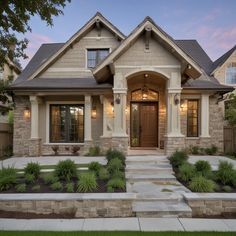 a house that is in the evening with lights on and landscaping around its front yard