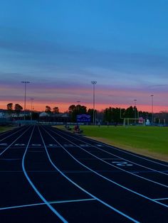 the sun is setting over an empty track