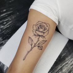 a black and white rose tattoo on the arm