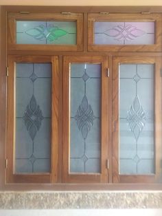 three glass doors with decorative designs on the front and side panels, all in different colors