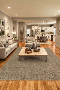 a living room filled with furniture and a wooden table in front of a couch on top of a hard wood floor