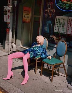 a mannequin is sitting on a chair in front of a store with pink tights