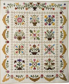 a white quilt with flowers and plants on it