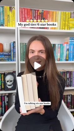 a woman holding a book in front of bookshelves with text reading my god tier 6 star books