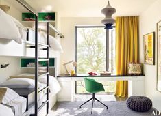 a bedroom with bunk beds, desk and chair next to a yellow curtained window