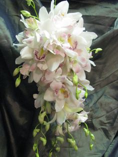 a bouquet of white and pink flowers sitting on top of a black cloth covered table