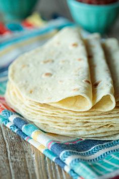 a stack of tortillas sitting on top of a wooden table