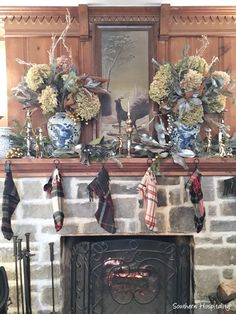 a fireplace with stockings hanging from it's mantle and wreaths on the mantel