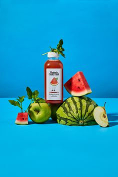 a bottle of ketchup sitting next to some watermelon slices and apples