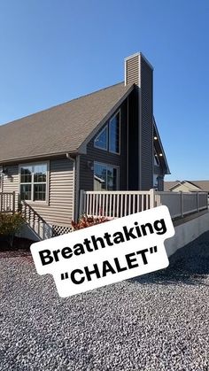 there is a sign that says breathtaking chalet in front of a house on gravel