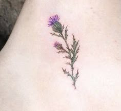 a small flower tattoo on the back of a woman's neck and ankle area