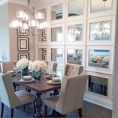 a dinning room table with chairs and pictures on the wall in front of it