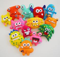 a bunch of stuffed animals that are on a white surface with eyes and mouth shapes