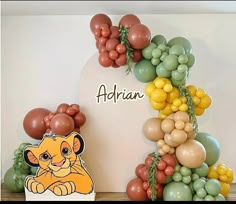 there is a lion balloon arch with balloons on it and the name arian above it