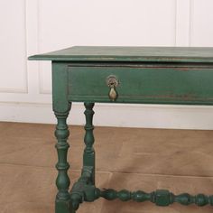 an old green table with two drawers on one side and a drawer on the other