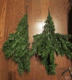 three christmas trees are hanging from hooks on the floor