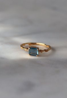 a gold ring with an aqua blue stone