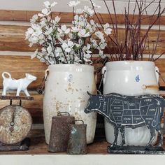 some vases with animals and flowers in them on a shelf next to a clock