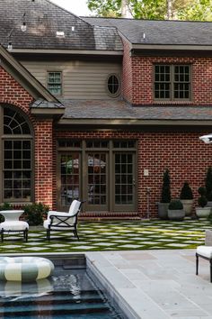 an outdoor patio with chairs and tables next to a pool