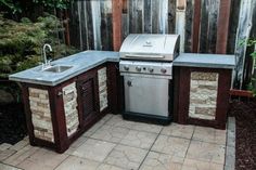 an outdoor kitchen with grill and sink