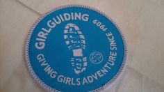 a blue and white patch with the words girl guiding going girls adventures on it's side