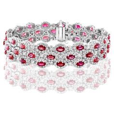 A beautiful vivid red Rubies and Diamond 3-row bracelet showcasing color-rich Rubies, surrounded by a single row of brilliant round diamonds. 51 Oval cut rubies weigh 14.91 carats total; 561 accent diamonds weigh 9.66 carats total. Made in 14k white gold. Style is available in different price ranges. Prices are based on your selection. Please contact us for more information. Luxury Red Diamond Jubilee Bracelet, Luxury Red Diamond Bracelet, Red Luxury Diamond Bracelet, Red Diamond Oval Bracelet, Luxury Red Diamond Bracelet For Anniversary, Luxury Red Ruby Tennis Bracelet, Red Oval Diamond Bracelet, Luxury Red Diamond Tennis Bracelet, Luxury Red Tennis Bracelet