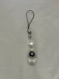 a black and white cell phone charm with a bow