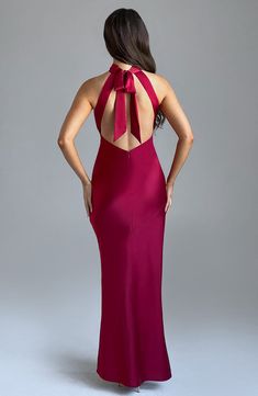 the back of a woman in a red dress with a large bow on her neck