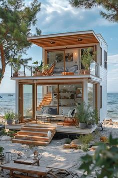 a small house on the beach with stairs leading up to it's second floor